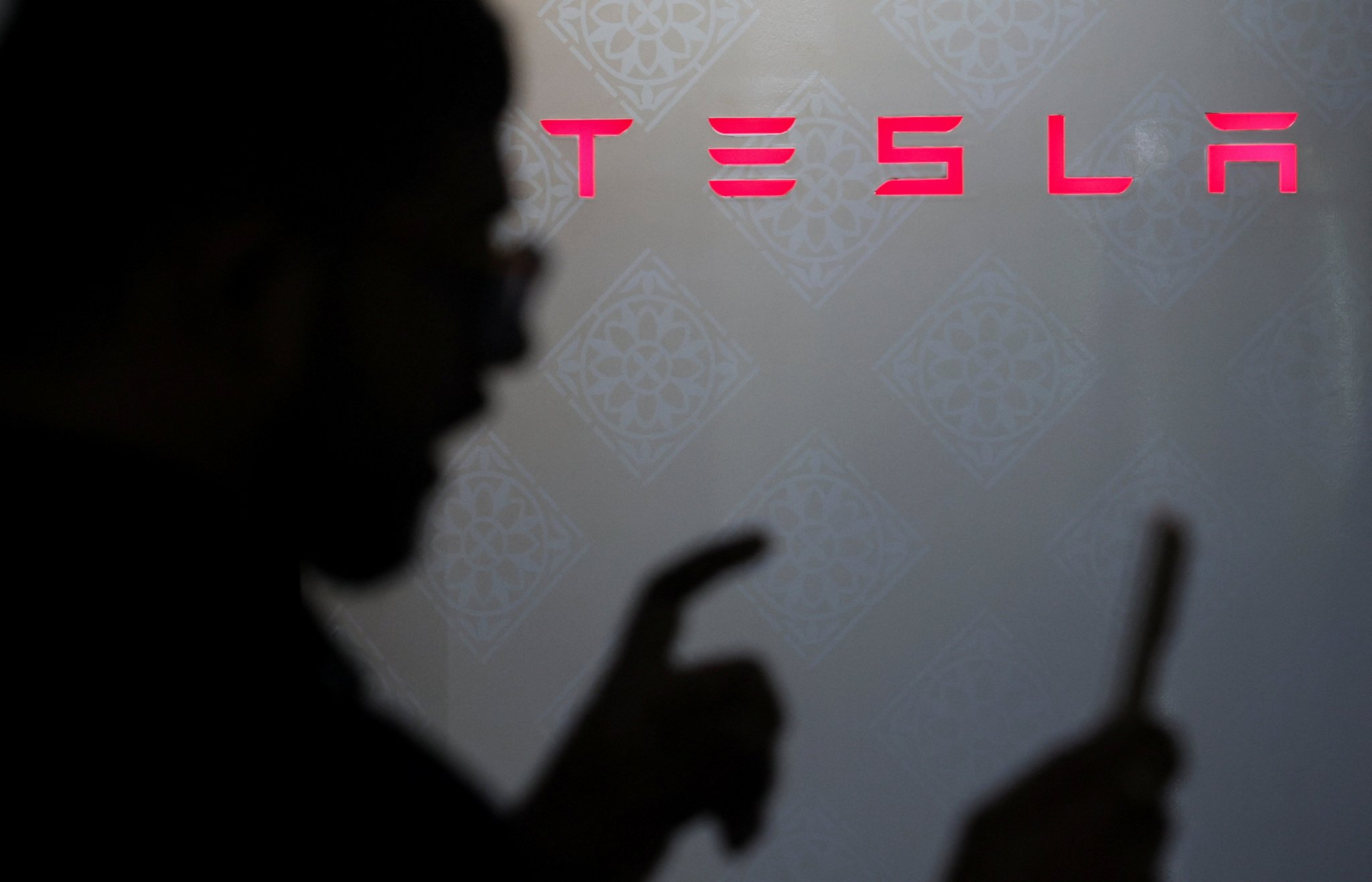 A man speaks in front of a Tesla logo at a charging station in Mumbai, India, August 4, 2025. [REUTERS/YONHAP]