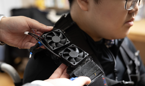 Myung Ha-yul, a student diagnosed with Duchenne muscular dystrophy, tries on a wearable robot developed by the Korea Institute of Machinery and Materials (KIMM) at his home in southern Seoul on Dec. 19, 2025. [JUN MIN-KYU]