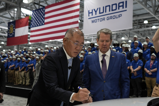 Hyundai Motor Group Executive Chair Euisun Chung, left, stands with Georgia Gov. Brian Kemp as Chung signs an Ioniq 9 EV vehicle during the grand opening of Hyundai Motor Group Metaplant America in Ellabell, Georgia, on March 26, 2025. [AP/YONHAP]