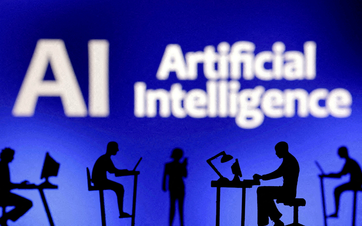 Figurines with computers and smartphones are seen in front of the words ″Artificial Intelligence AI″ in this illustration from Feb. 19, 2024. [REUTERS/YONHAP]