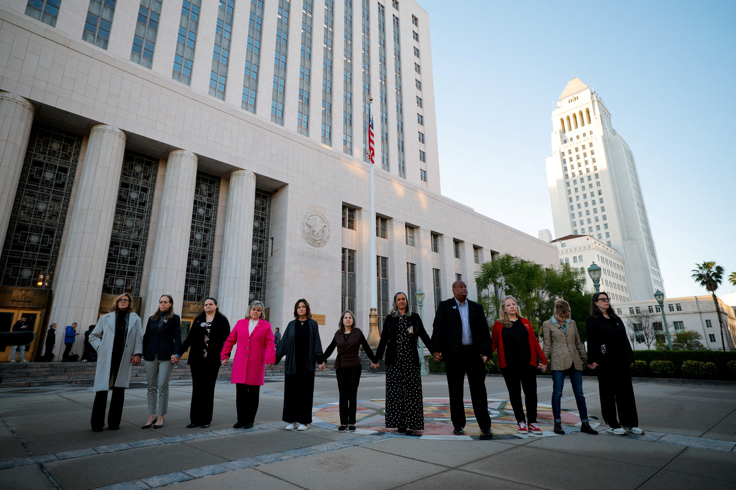 Parents, who say they lost their children because of social media, stand outside a court in Los Angeles on Feb. 18 holding hands ahead of Meta Platforms CEO Mark Zuckerberg's arrival to take the stand at trial in a key test case accusing Meta and Google's YouTube of harming kids' mental health through addictive platforms.  [REUTERS/YONHAP]