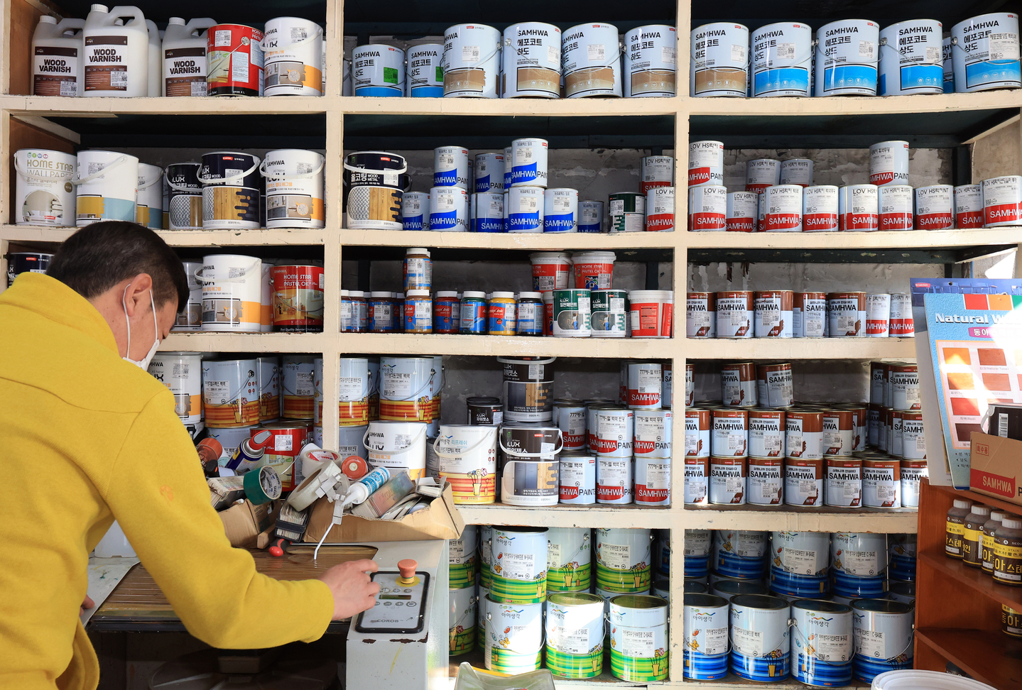 An employee organizes paint cans at a paint store in Seoul on March 25. [NEWS1]