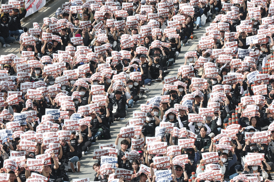 Members of Samsung Electronics-affiliated labor unions hold up placards calling on the company to scrap a longstanding cap on bonuses during a massive rally inside the company's campus in Pyeongtaek, Gyeonggi, on April 23. [YONHAP]
