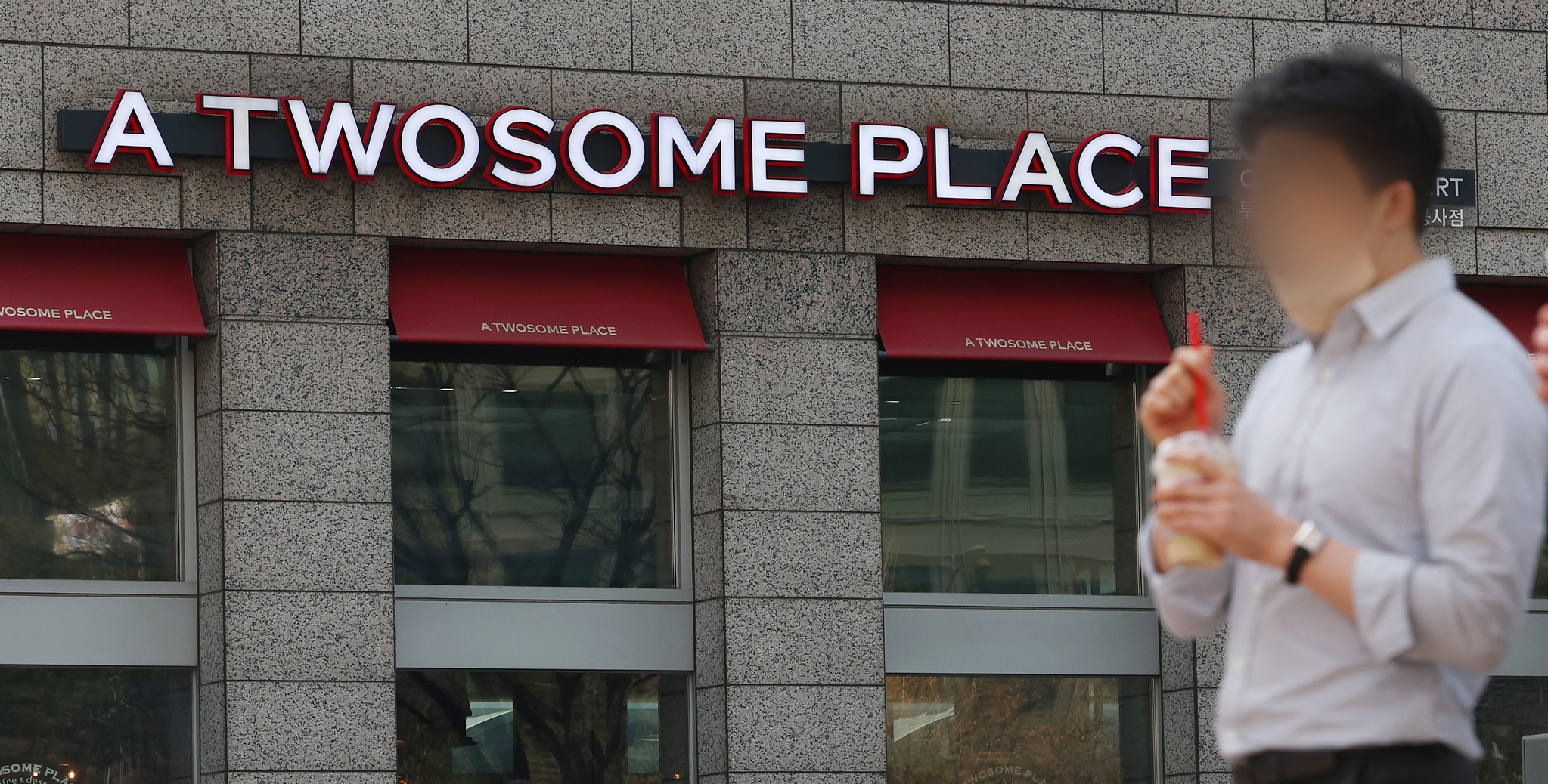 A passerby walks in front of a Twosome Place branch in Seoul on March 24. [YONHAP]